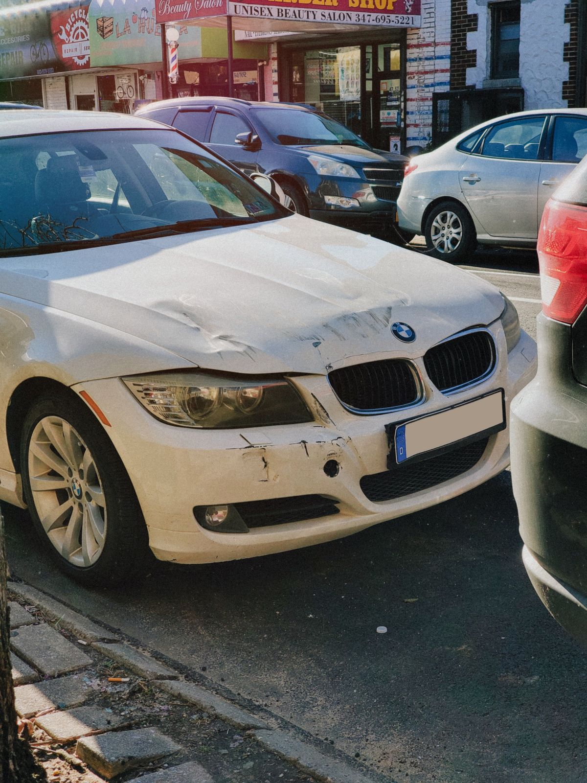 Real white sedan with visible front-end collision damage